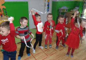 Dzieci tańczą w kole z paskami bibuły